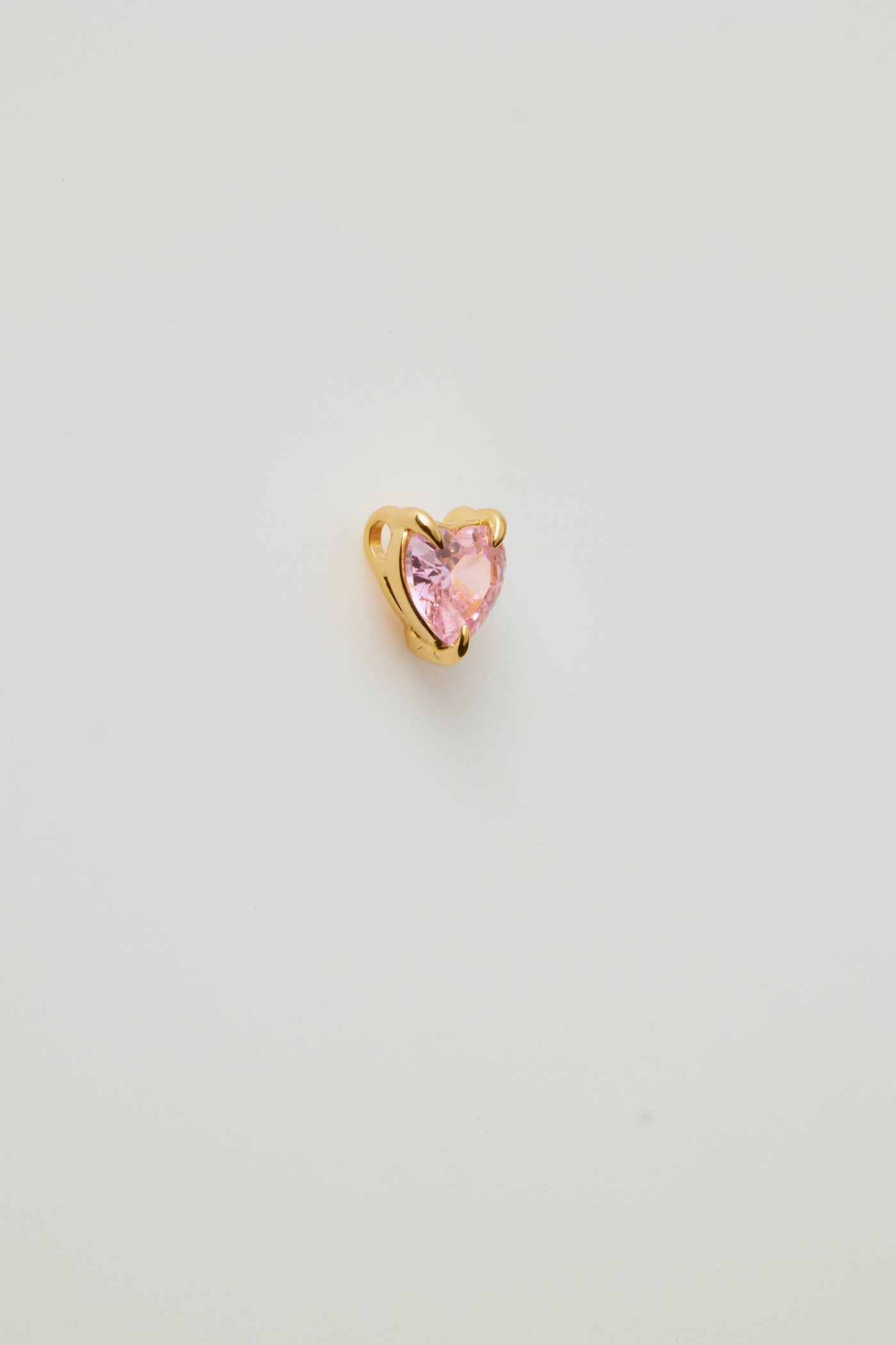 Side view of a pink faceted heart charm set in polished gold, featuring a sparkling gemstone-like finish. Elegant and perfect for any chain.