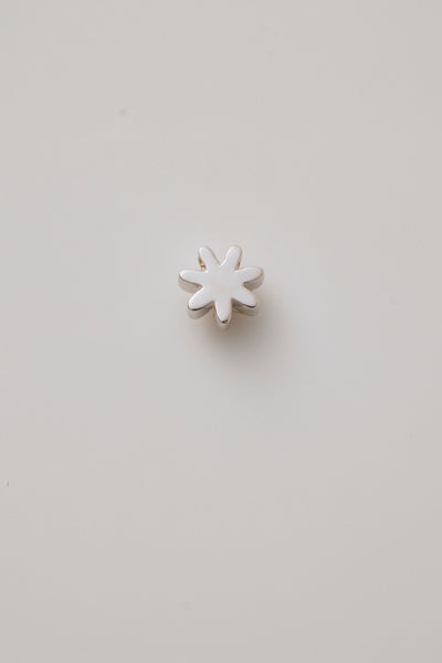 Back reverse view of a white gold three-dimensional daisy charm with detailed petals.