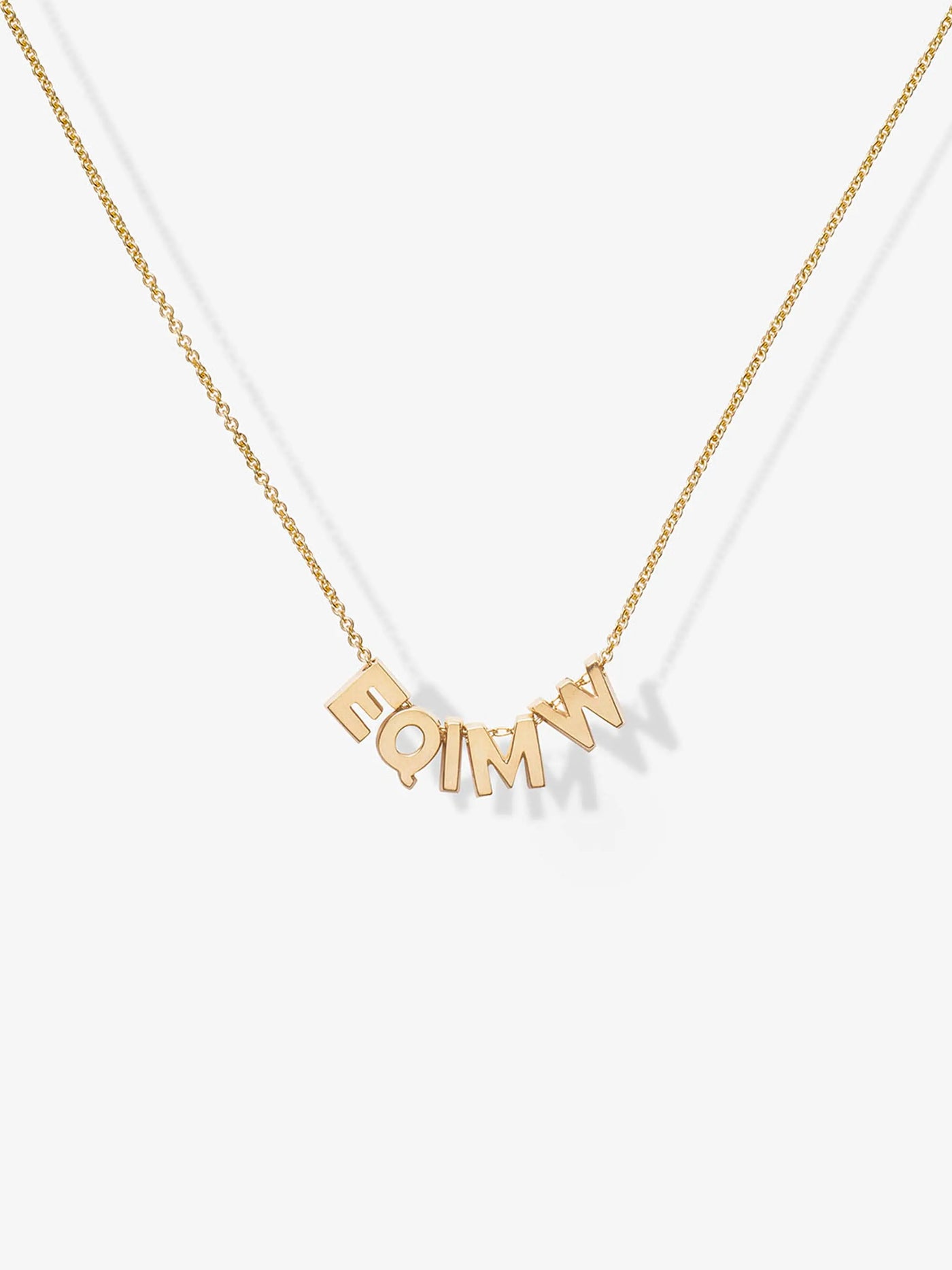 The Five Letters Necklace in 18k Gold is a delicate chain necklace adorned with five solid gold letters - E, Q, I, M, and W hanging gracefully at the center. These evenly spaced letters form an abstract or acronymic design that stands out beautifully against a white background.