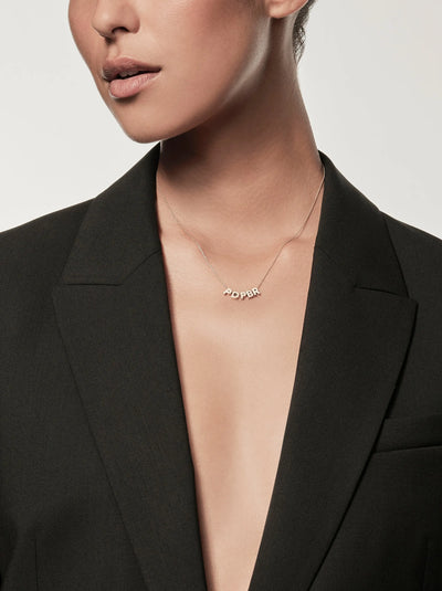 The Five Letters Necklace in 18k Gold is a delicate chain necklace adorned with five solid gold letters hanging gracefully at the center. These evenly spaced letters form an abstract or acronymic design that stands out beautifully against a white background.