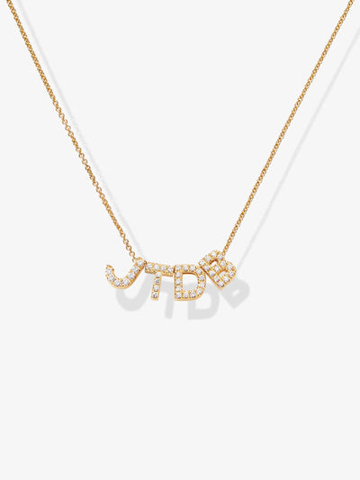 An elegant piece, the Four Letters Necklace in Diamonds and 18k Gold embellished with small, shimmering diamonds. The charm is seamlessly integrated into the chain, casting a subtle shadow on a plain white background.