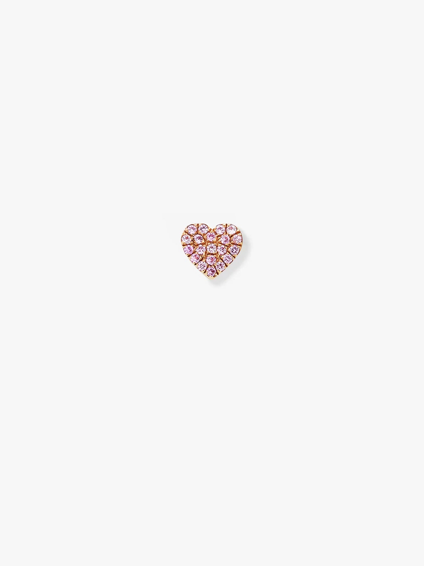 The "Heart in Pink Sapphire and 18k Gold" earring is a single heart-shaped stud encrusted with small pink sapphires, crafted from 18k solid gold. The earring is set against a plain white background.