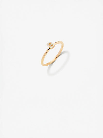 An elegant custom-made Letter B Ring in Diamonds and 18k Gold with a square-shaped setting encrusted with small diamonds, showcased against a minimalistic white background. The ring's shadow is visible slightly to the right on the surface.