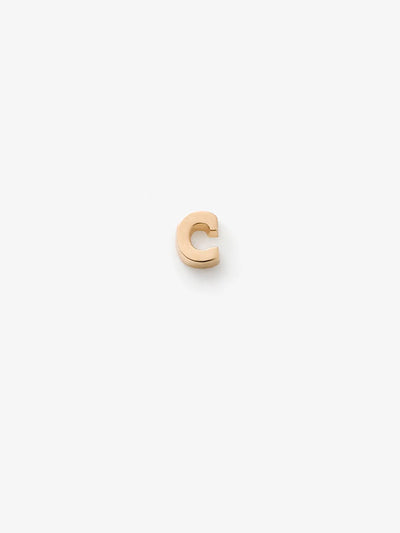 A small, shiny gold-colored "C" charm made from 18k solid gold, featured on a plain white background. The letter is raised and catches the light beautifully.