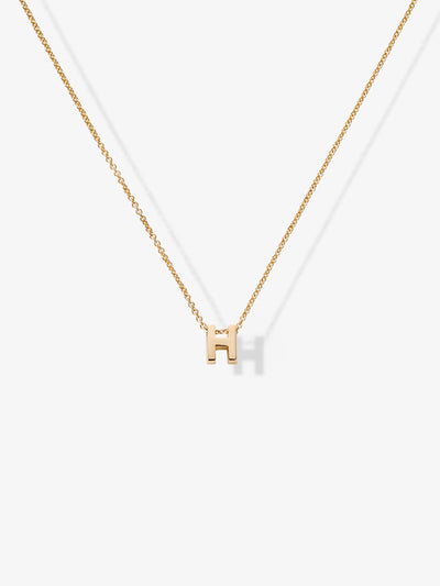 Introducing the Letter H Necklace in 18k Gold: a delicate necklace featuring a small, solid gold capital letter "H" pendant at the center, set on an elegant 18k gold chain against a plain white background.