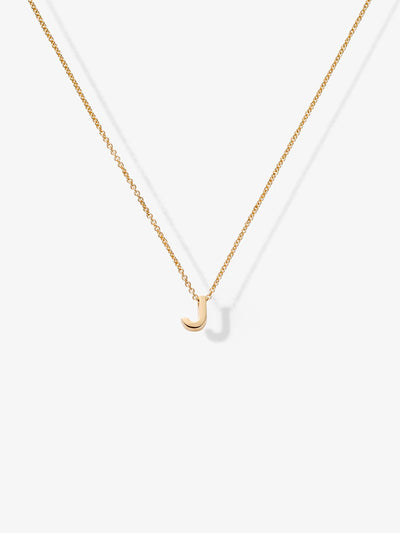 The Letter J Necklace in 18k Gold showcases a small, gold letter "J" pendant at its center, delicately hanging from a gold chain. Crafted from 18k solid gold, the necklace includes openable connectors for easy wear and is elegantly displayed against a plain white background.