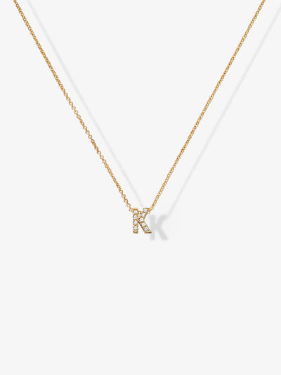 A finely crafted piece, the Letter K Necklace in Diamonds and 18k Gold showcases a delicate solid gold chain featuring a small "K" pendant adorned with shimmering gemstones, all set against a plain white background.