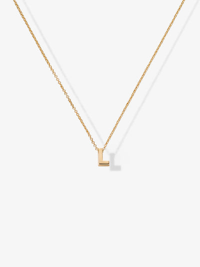 The Letter L Necklace in 18k Gold showcases a minimalist "L" shaped pendant at the center of a simple chain, set against a plain white background. The delicate 18k gold pendant features clean lines and a shiny finish, making it an elegant addition to any collection of charms.