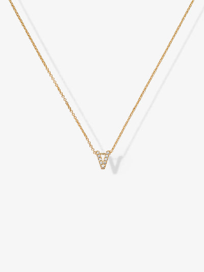 A delicate "Letter V Necklace in Diamonds and 18k Gold," featuring a thin chain and a small, V-shaped pendant encrusted with tiny, sparkling diamonds, is photographed against a plain white background. The necklace's shadow is visible.