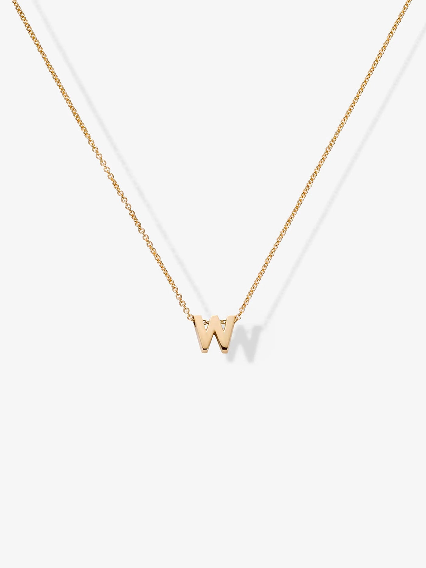 The Letter W Necklace in 18k Gold showcases a delicate small "W" pendant hanging from a fine chain. The centered pendant stands out against a plain white background, highlighting the elegance of personalized jewelry.