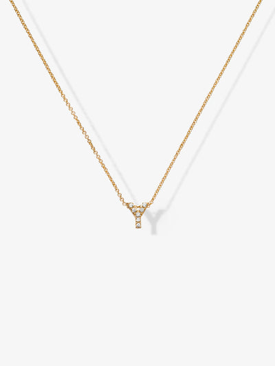 Introducing the Letter Y Necklace in Diamonds and 18k Gold: This delicate accessory features a small, elegant "Y" pendant adorned with tiny diamonds. The chain and pendant catch the light beautifully, showcasing a simple yet sophisticated design against a pristine white background.