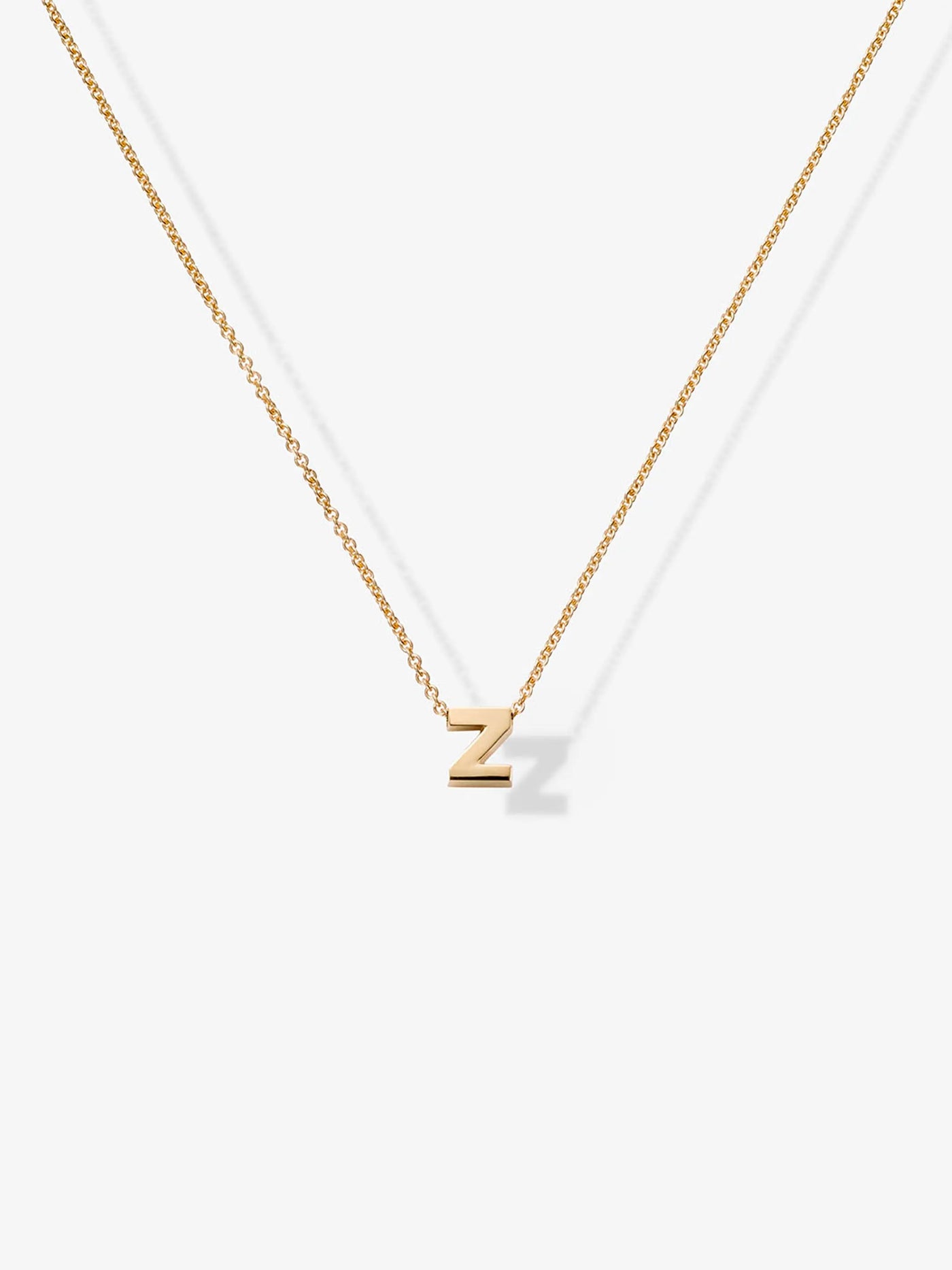 The Letter Z Necklace in 18k Gold showcases a delicate design with a simple, thin 18k solid gold chain and a perfectly centered gold pendant in the shape of the letter "Z," standing out gracefully against the plain, white background.