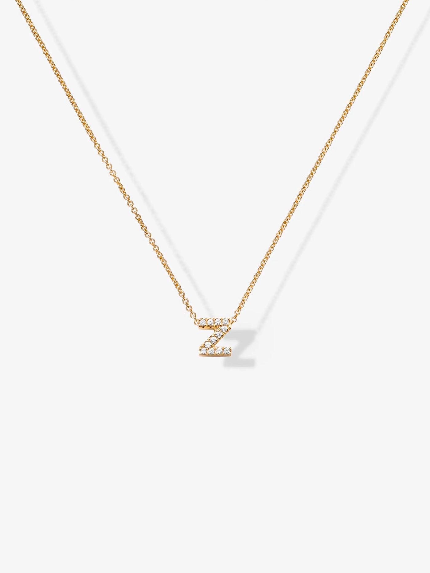 The Letter Z Necklace in Diamonds and 18k Gold features a thin chain paired with a pendant shaped like the letter "Z," encrusted with small, sparkling diamonds that add a touch of elegance to its simple and sophisticated design.