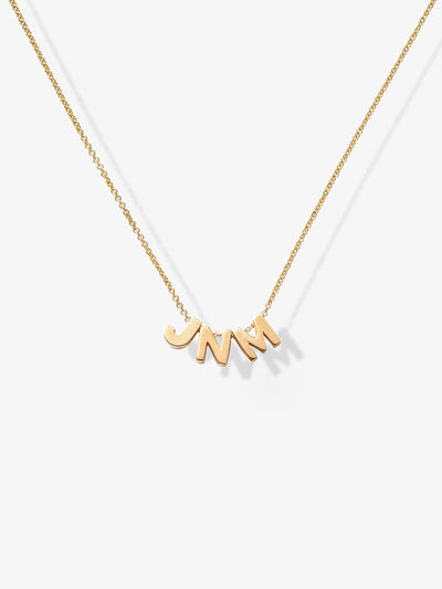 The Three Letters Necklace in 18k Gold is a delicate piece featuring three polished gold letters as the pendants. This sophisticated necklace, with its fine chain, gracefully displays the initials "JNM," which hang prominently at the center, casting a slight shadow on any light background.