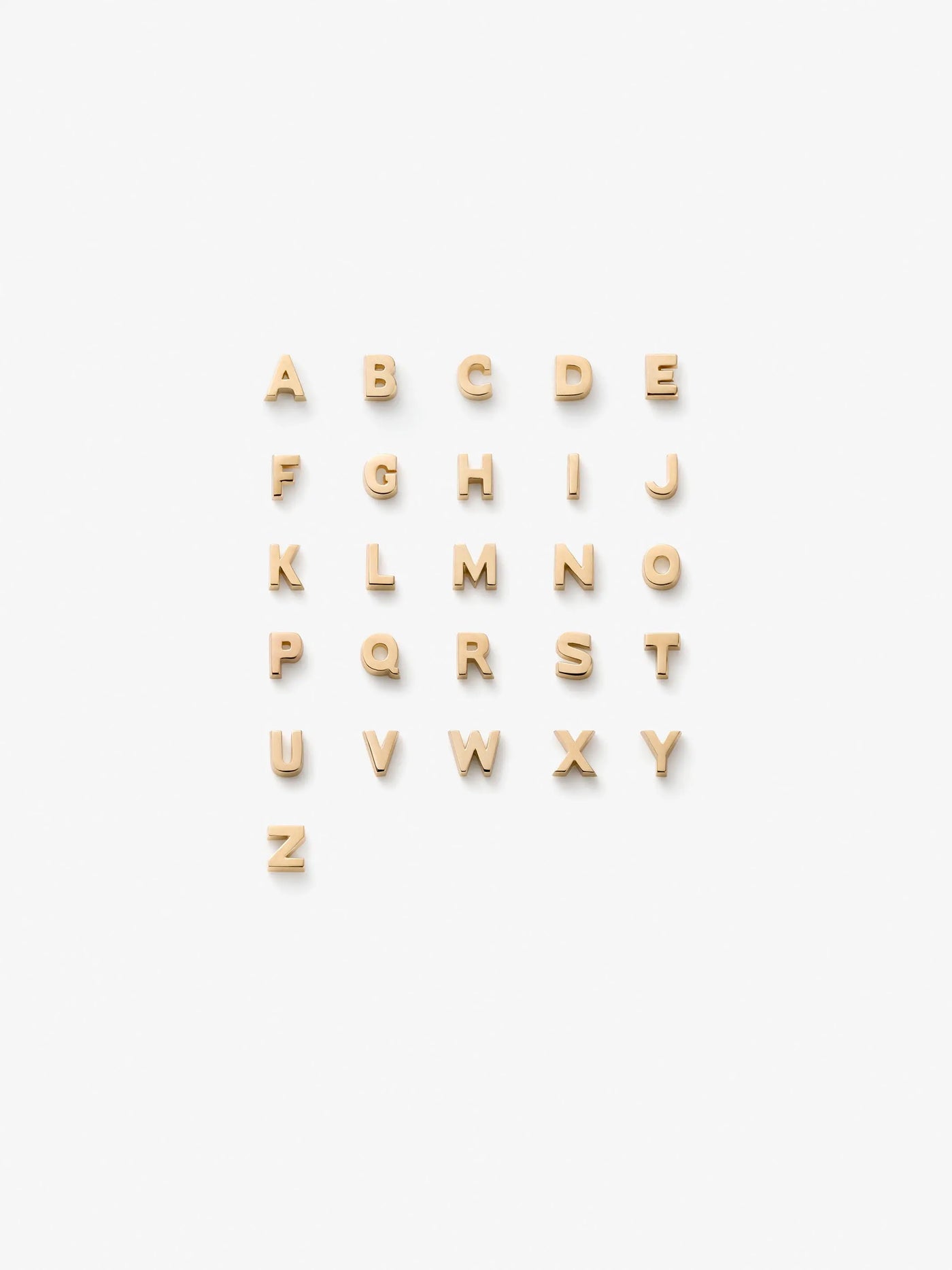 A grid of 18k solid gold alphabet letters. The letter charms are arranged in alphabetical order on a white background from A to Z