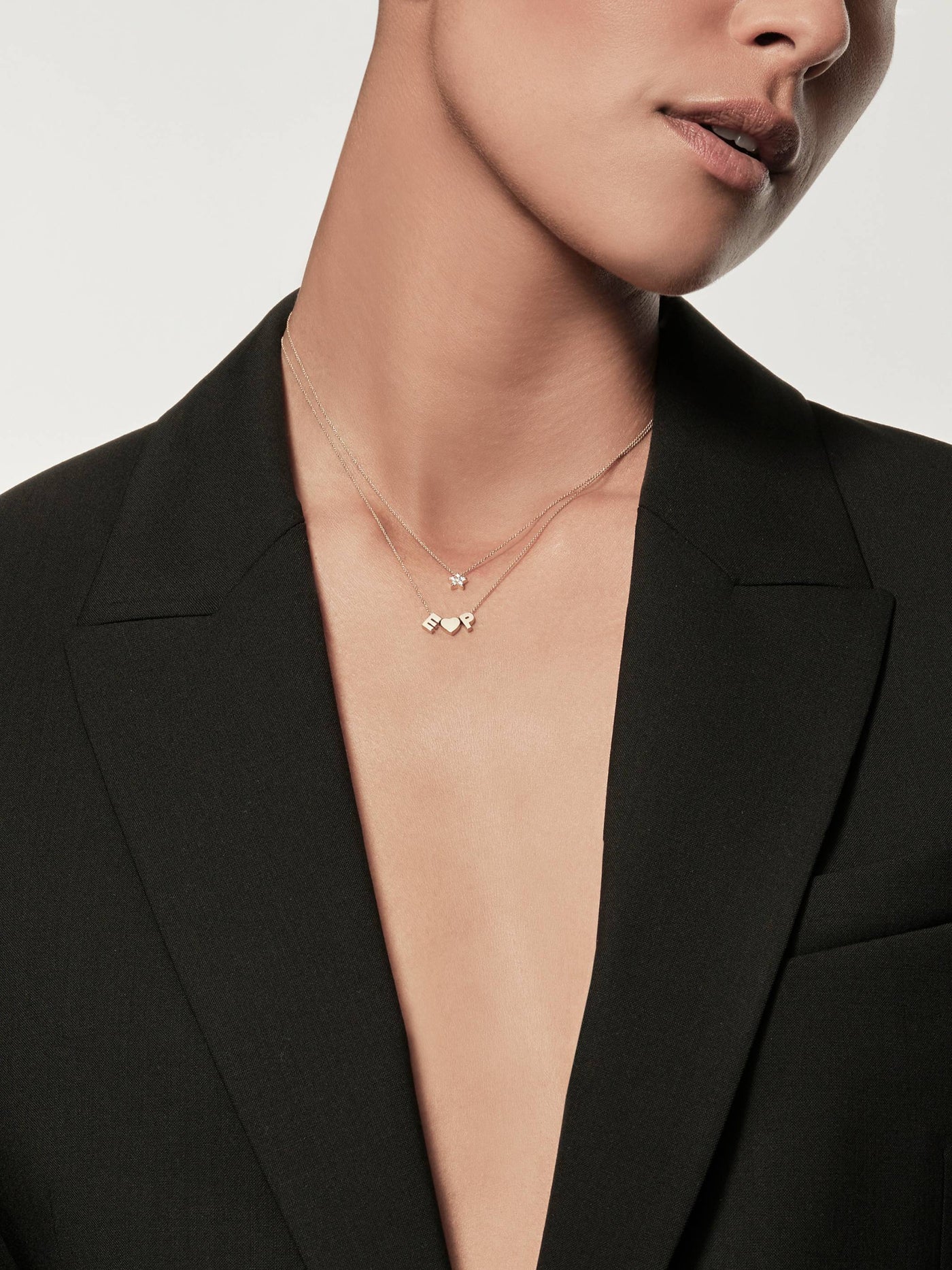 Model wearing a Miniature three-dimensional star in 18k solid gold and diamonds, thread onto an adjustable chain.