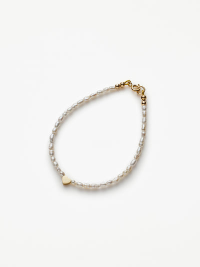 Hand-strung bracelet with natural freshwater pearls and miniature three-dimensional heart in 18k solid gold