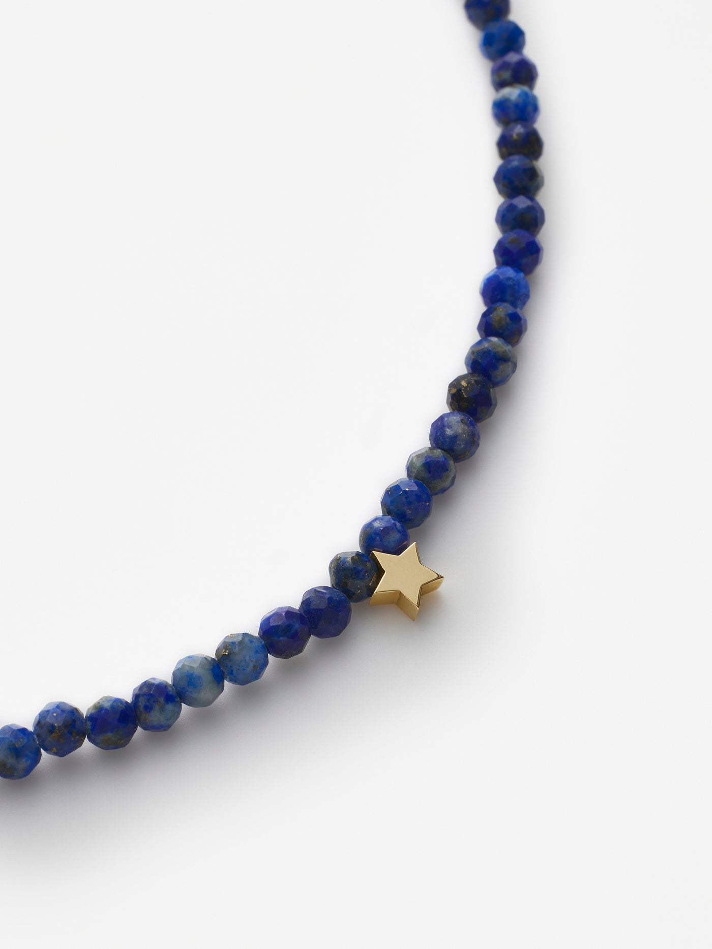 Hand-strung bracelet with natural lapis lazuli gemstones and miniature three-dimensional star in 18k solid gold